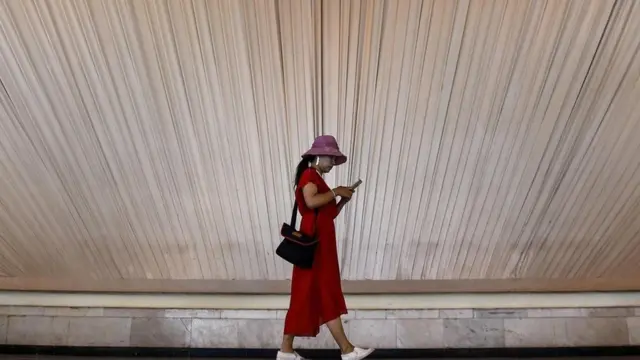 سيدة تستخدم هاتفها المحمول بينما تسير في الشارع