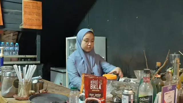 Penjaga warung kopi di Makasar bernama Nur Ainun Putri, 22 tahun, mengatakan tidak menggunakan masker saat bekerja.