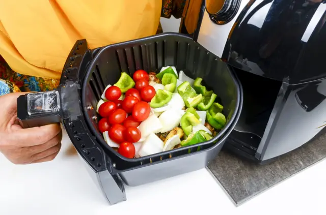 Pessoa colocando legumes para preparar na air fryer