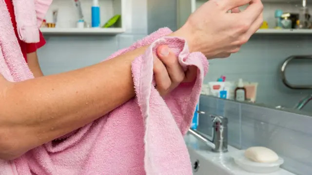 una persona secando su brazo.