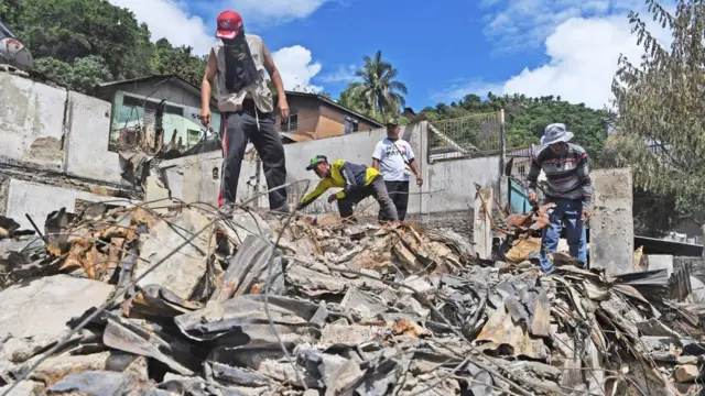 Warga mengumpulkan benda yang masih berharga dari sisa kebakaran rumah warga di Kota Jayapura, Papua, Senin (02/09)