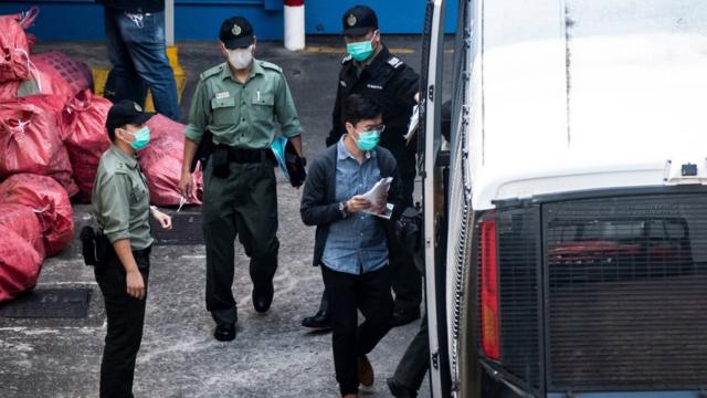 前香港立法會議員區諾軒（圖中藍色上衣者）在九龍荔枝角收押所被押上囚車（2/3/2021）