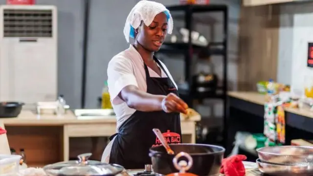 Hilda Baci wọ aṣọ ìdáná nínú ilé ìdáná nígbà ptó ń ṣe ìpèníjà síse oúnjẹ fún ìgbà tó pẹ́ jùlọ lọ́dún 2023