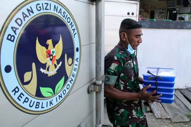Seorang anggota Babinsa TNI membawa makanan untuk dibagikan dalam program Makan Bergizi Gratis (MBG) di Sekolah Luar Biasa (SLB) Kota Lhokseumawe, Aceh, Kamis (20/02).