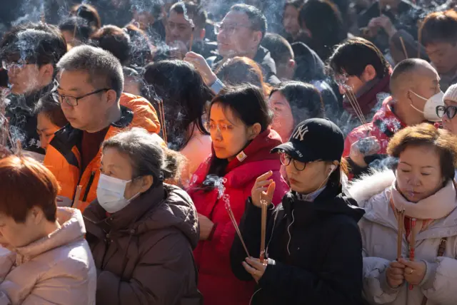 Люди молятся и жгут благовония