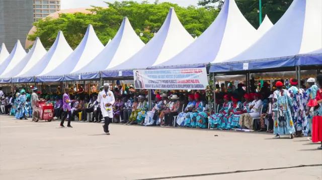 People sitting under the canopy at a campaign ground