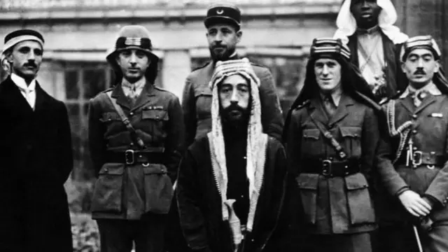 الأمير فيصل، الذي صار بعد ذلك ملك العراق، مع أفراد حاشيته في مؤتمر باريس للسلام عام 1919 ويظهر على يمينه العقيد لورانس بغطاء الرأس العربي، كما يظهر نوري السعيد (الثاني من يسار الصورة) الذي صار رئيسا للوزراء فيما بعد