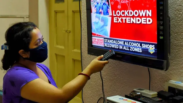 લૉકડાઉનના સમચાર નિહાળી રહેલી મહિલાની તસવીર