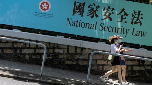 两名女路人走过一面宣传香港《国安法》横幅（15/7/2020）