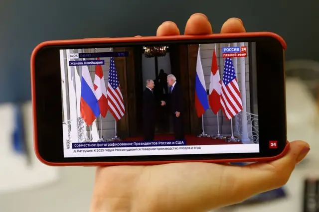 A press member in Moscow follows the summit on a mobile phone