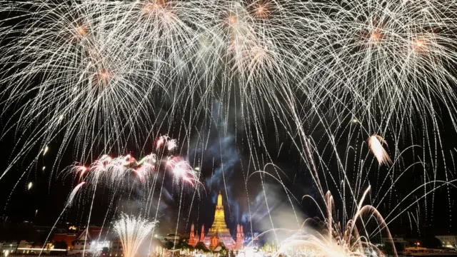 Fireworks explode ova di Chao Phraya River for Bangkok, Thailand as di clocks struck midnight