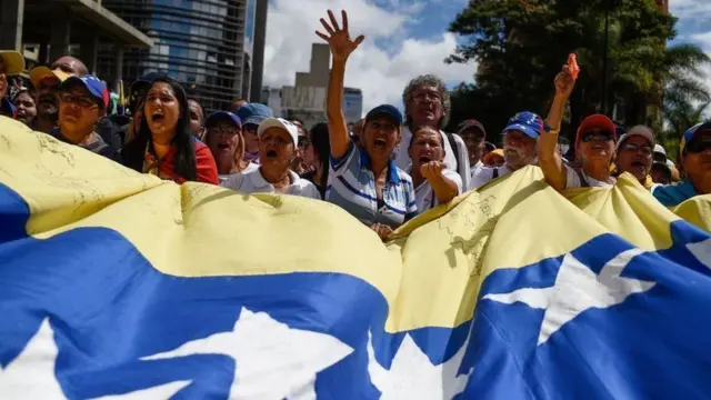 Dezenascorridas de cavalos bet365venezuelanos gritam e seguram bandeira do paíscorridas de cavalos bet365protesto na rua