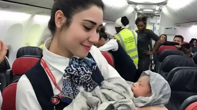 बच्चे को गोद में लिए एक एयर होस्टेस.