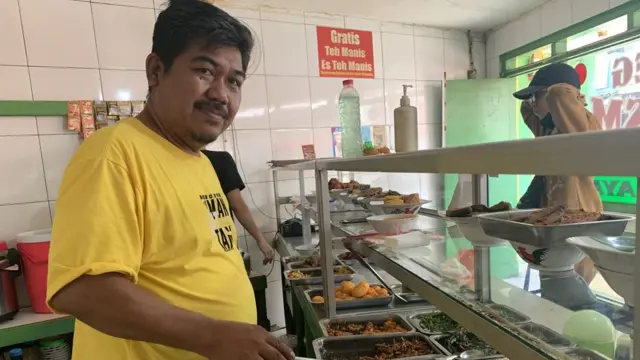 Warto, pemilik warteg Kharisma Bahari cabang kampus Binus Syahdan Palmerah, menyiapkan pilihan lauk menjelang jam makan siang.