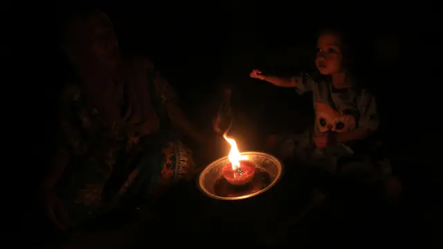 Warga bersama anak menggunakan lampu penerangan tradisional saat terjadi pemadaman listrik di Desa Suak Raya, Johan Pahlawan, Aceh Barat, Aceh, Sabtu (23/5/2026). Sebagian wilayah di Aceh masih terdampak pemadaman listrik bergilir yang dipicu gangguan pada sistem transmisi interkoneksi Saluran Udara Tegangan Tinggi (SUTET) 275 kV lintas Sumatera.