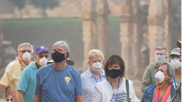 మాస్కులతో తిరుగుతున్న పర్యాటకులు