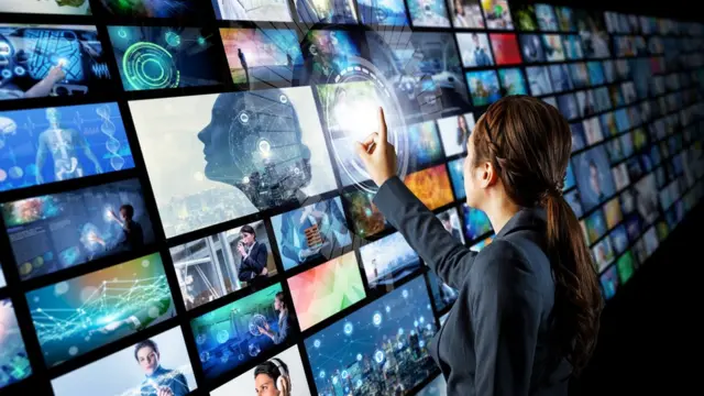 Una mujer frente a una pantalla múltiple