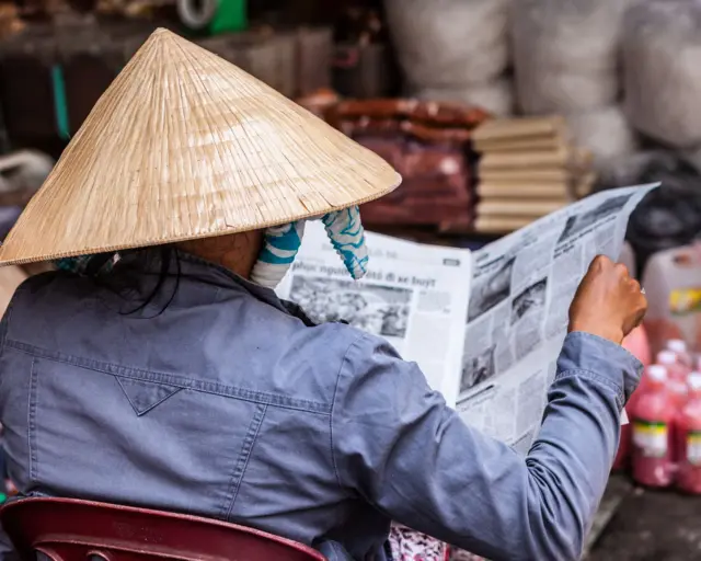 Một người phụ nữ đọc báo tại TP HCM 