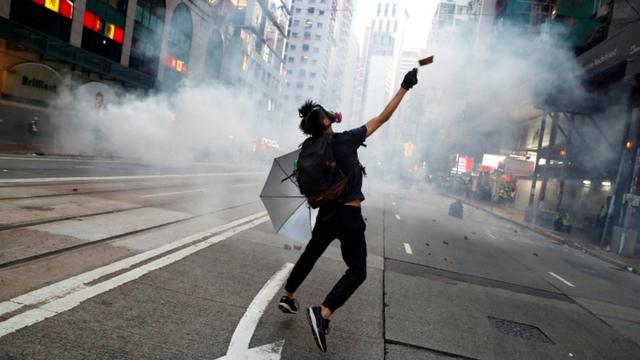 An anti-government protester reacts as police fire tear gas during a march billed as a global "emergency call" for autonomy, in Hong Kong, China, on 2 November 2019