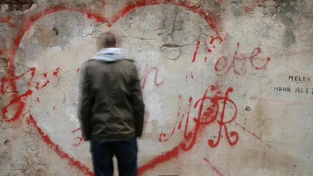 一名男子在读墙上的语言