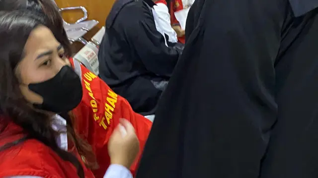 Astri mengenakan masker di ruang sidang