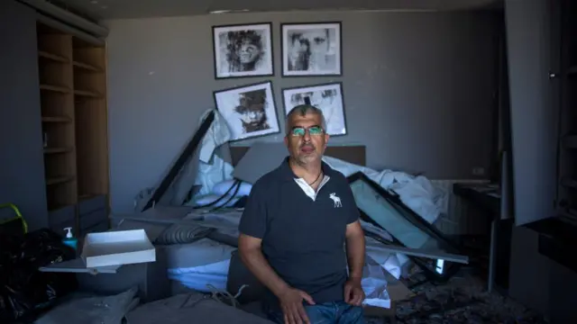 A man sits in his house the day after the explosion