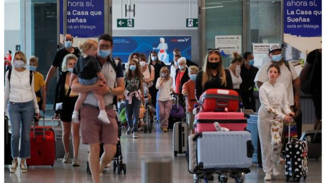 British tourists wearing protective face masks walk with their luggage, as they arrive at Malaga-Costa del Sol Airport for sightseeing, amid the coronavirus disease (COVID-19) outbreak in Malaga, Spain, July 19, 2021. REUTERS/Jon Nazca