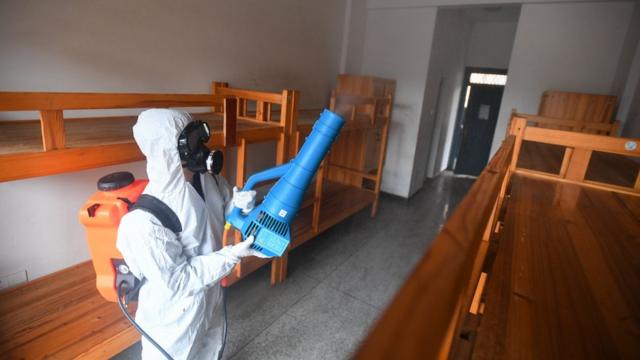 3月12日，在长沙市长雅中学，工作人员对学生宿舍进行消毒，准备开学。