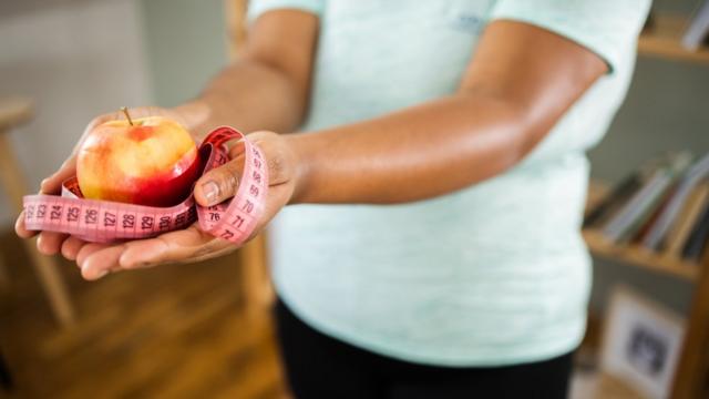 Femme qui tient une pomme