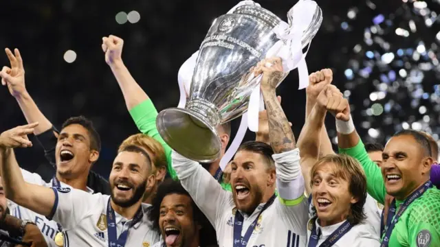 रियल मैड्रिड के खिलाड़ी इटली की टीम जुवैंटस को हराने के बाद ट्रॉफ़ी के साथ