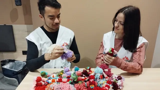 Camilo y una colega de MSF con las muñecas tradicionales tejidas por una de las pacientes
