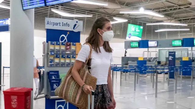 Passengers with face masks at the main departure hall in the terminal of Athens International Airport in Greece
