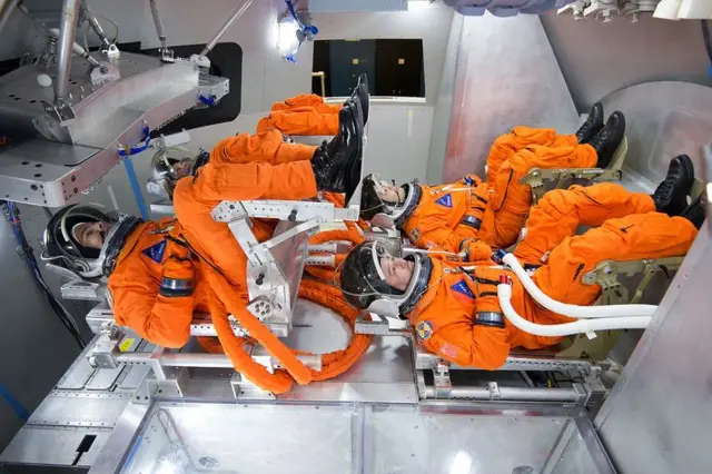 Uma vista da disposição dos assentos da tripulação — dois assentos acima de dois assentos — usando uma maquete do veículo no Centro Espacial Johnson.