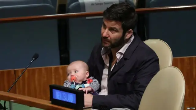 Clarke Gayford, partner to New Zealand Prime Minister Jacinda Ardern holds their baby Neve as Ardern speaks at the Nelson Mandela Peace Summit