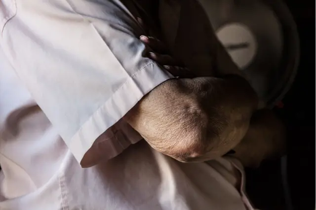 கைக்கட்டி கொண்டிருக்கும் பெரியவர்