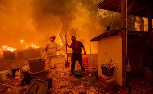Dos personas trabajando entre las llamas.