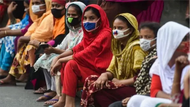 মাস্ক পরা নারীরা বসে আছেন