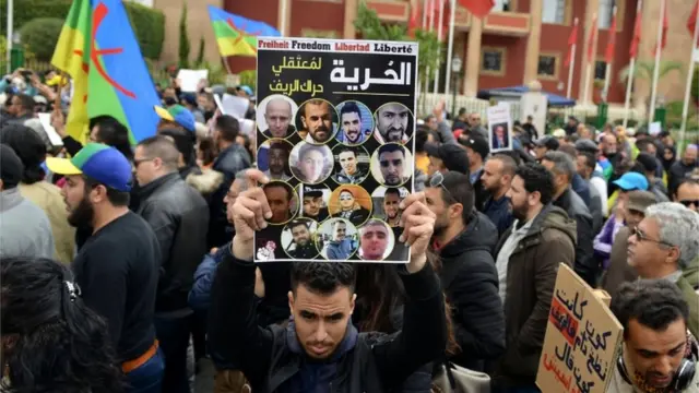 A Moroccan protester holds a banner reading in Arabic "freedom for Hirak Rif detainees"