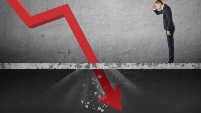 Un hombre mira a una línea que cae.