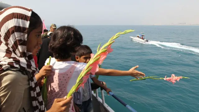 Personas arrojan flores el mar
