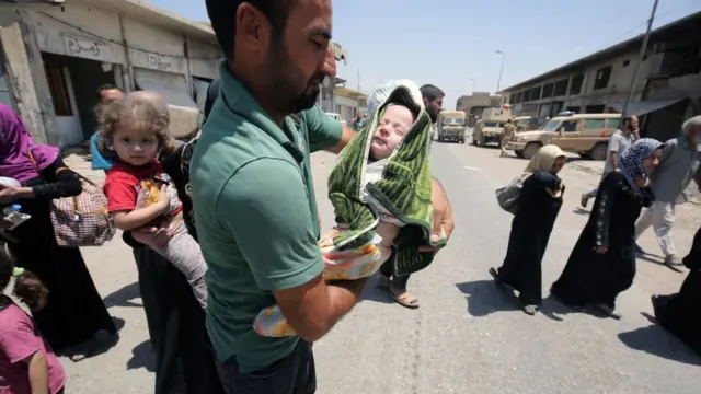 குழந்தைகளோடு இடம்பெயரும் மக்கள்