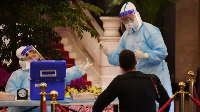 政协会议开幕前，医务人员对参会者采集样本进行新冠病毒测试。