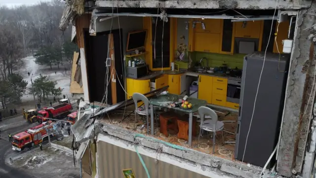 A cozinha amarela vista com a parede arrancada