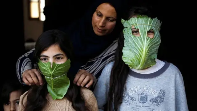 Палестинська жінка розважає своїх дітей масками з капусти