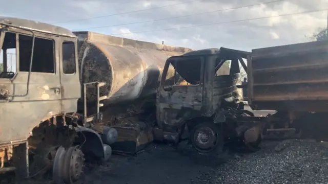 The burnt remains of the trucks involved in the collision