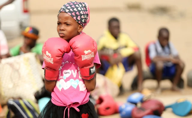 A girl in pink boxing gloves in Lagos, Nigeria - Saturday 5 March 2022