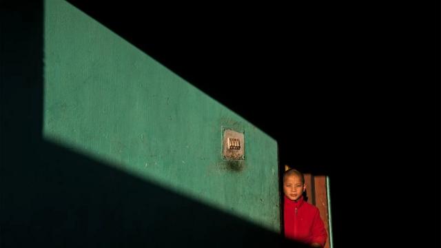 Un niño se asoma por una puerta en Bután