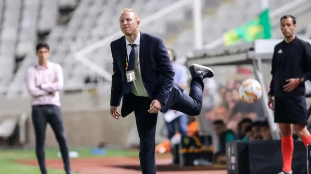 አሰልጣኝ በከፍተኛ ጉጉት ኳስ ሲመለከቱ