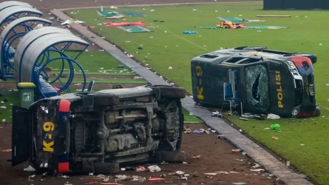 Veículos policiais danificados ficaram no campo dentro do estádio Kanjuruhan