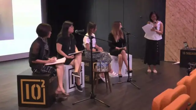 ภาพแคปจากคลิป กลุ่มผู้หญิงนั่งและยืนบนเวที